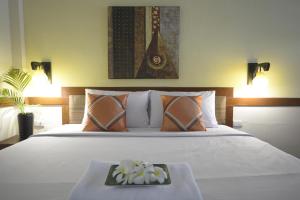 a bedroom with a bed with a tray of flowers on it at iRest Ao Nang Seafront in Ao Nang Beach