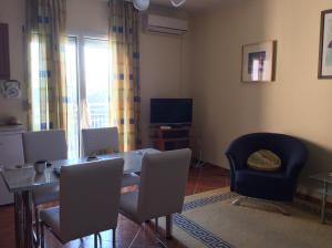 une salle à manger avec une table, des chaises et une télévision dans l'établissement Rehab Apartment, à Hévíz