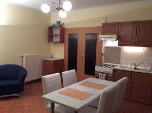 cocina con mesa y sillas y cocina con fogones en Rehab Apartment, en Hévíz