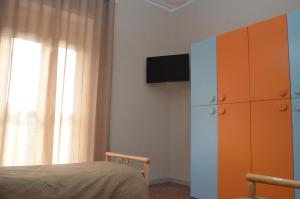 ein Schlafzimmer mit einem Bett, einem Schrank und einem TV in der Unterkunft Calabrese Family in Pompei
