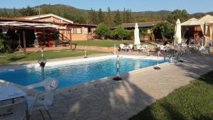 a swimming pool with chairs and umbrellas next to a house at Il Frutteto in Sant' Isidoro