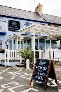 a sign in front of a restaurant with a sign for a street at Ship Inn in Aberporth