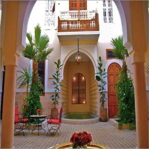 a building with a courtyard with a table and chairs at Riad Rabahsadia in Marrakech