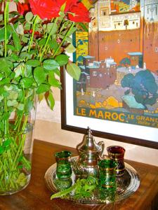 uma mesa com um vaso com flores e uma imagem em Riad Rabahsadia em Marraquexe