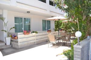 a patio with a table with chairs and an umbrella at Marianna Hotel Apartments in Limassol