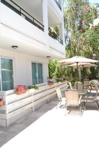 a patio with a table and chairs and an umbrella at Marianna Hotel Apartments in Limassol