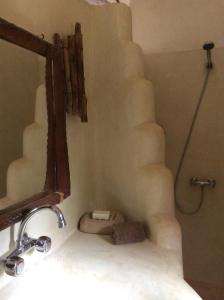 a bathroom with a sink and a mirror and stairs at Tama Lodge in Mbour