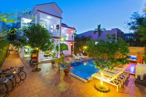 una casa con piscina por la noche en Hoi An Life Villa, en Hoi An