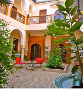 a house with two chairs and a table in a courtyard at Riad Rabahsadia in Marrakech