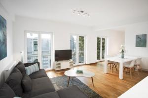 un salon avec un canapé et une table dans l'établissement Victoria City and Kö Apartments, à Düsseldorf