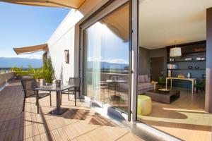 einen Balkon mit einem Tisch und ein Wohnzimmer in der Unterkunft Crowne Plaza Geneva, an IHG Hotel in Genf