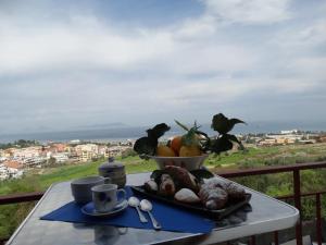 a table with a plate of food on a table with a view at Canapè Apartments in Patti