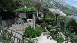 ein Haus mit Garten an der Seite eines Berges in der Unterkunft Apartment Capt Seferovic in Donji Morinj