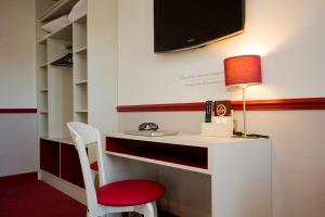 a room with a desk with a lamp and a chair at Hotel des 4 Soeurs in Bordeaux