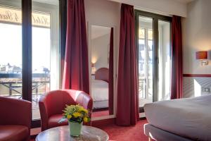 ein Hotelzimmer mit einem Bett und einem Tisch mit Blumen in der Unterkunft Hotel des 4 Soeurs in Bordeaux