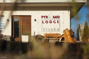 un bâtiment avec un panneau indiquant pyyn spirit lodge et un banc dans l'établissement HOTEL Pyramid Lodge, à Visoko