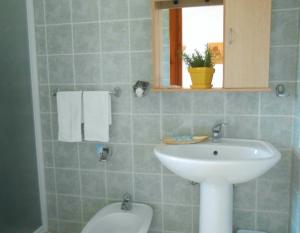 een badkamer met een wastafel en een toilet bij Hotel Velasole in Posada +66 foto's