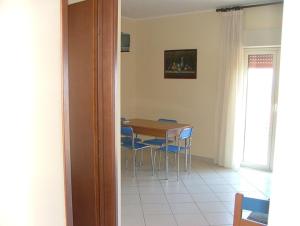 a dining room with a table and blue chairs at Canapè Apartments in Patti