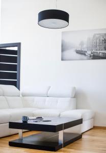 een woonkamer met een witte bank en een salontafel bij Red Brick Apartments in Klaipėda