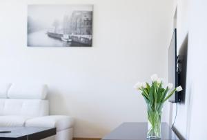 a living room with a vase of flowers on a table at Red Brick Apartments in Klaipėda