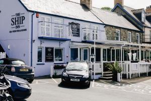 a car parked in front of a blue building at Ship Inn in Aberporth