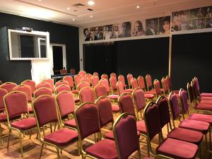 an empty room with red chairs and a podium at Hotel AL KARMEL in Tunis