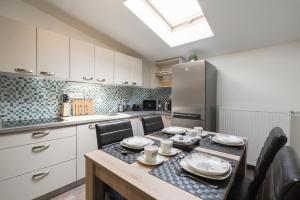 a kitchen with a table with chairs and a refrigerator at Čajkovskij Apartments Brno-jih in Brno