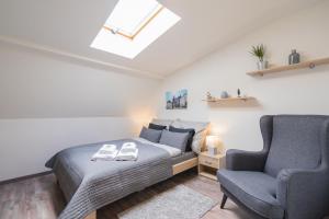 a bedroom with a bed and a chair at Čajkovskij Apartments Brno-jih in Brno