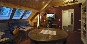 a living room with a table and a couch at Das Haus am Teich in Groß Grabow