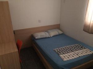 a small room with a small bed with a blue mattress at Hotel São João in Campinas