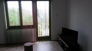 ein Wohnzimmer mit 2 Fenstern und einem Flachbild-TV in der Unterkunft S&G Apartment in Vranje