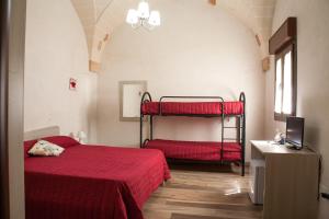 a bedroom with two bunk beds with red sheets at Le 5 Volte in Avetrana