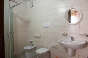 a bathroom with a sink and a toilet and a mirror at Le 5 Volte in Avetrana