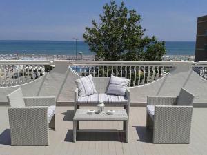 d'une terrasse avec des chaises et une table et la plage. dans l'établissement Hotel Rosalba, à Riccione