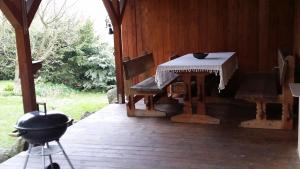 um alpendre com uma mesa, cadeiras e comodidades para churrascos em Chalupa v Krásné em Jablonec nad Nisou
