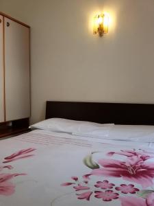 a bedroom with a bed with pink flowers on it at Albergo Luca in Ivrea