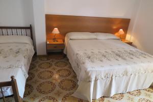 una camera d'albergo con due letti e due lampade di Appartamento Petrarca a Gallipoli