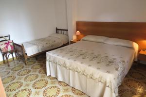 una camera con due letti, un tavolo e una sedia di Appartamento Petrarca a Gallipoli