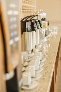 a row of coffee cups and cups on a counter at Bello Hotel in Toledo