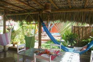 a patio with a table and chairs and a hammock at Casa Lagoa in Fortim