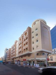 un gran edificio en una calle de la ciudad con en Florida Square Hotel (Previously known Flora Square Hotel), en Dubái