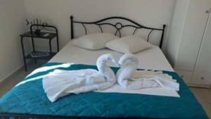 two towel swans sitting on top of a bed at Vigles in Adamantas