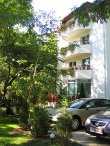 een wit gebouw met auto's ervoor geparkeerd bij Vila Elena in Eforie Nord