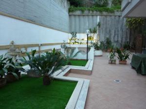einen Innenhof mit Topfpflanzen und einer Wand in der Unterkunft Posillipo Super Mono in Neapel