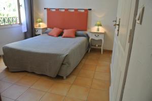 a bedroom with a bed with two tables and two lamps at Hôtel Castel Mistral in Juan-les-Pins