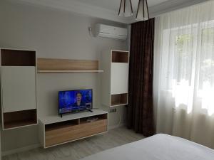 クルジュ・ナポカにあるApartament Verdeのベッドルーム(棚にテレビ付)、ベッド1台が備わります。