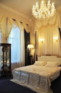 a bedroom with a large bed with a chandelier at Queen Valery Hotel in Odesa