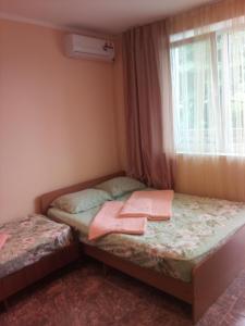 a small bedroom with two beds and a window at Dubrava Guest House in Loo