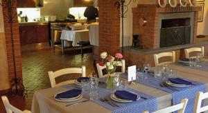 uma mesa de jantar com uma toalha de mesa azul e branca e flores em Agriturismo Bassanella em Treviglio
