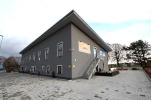 ein großes graues Gebäude mit einer Treppe auf einem Parkplatz in der Unterkunft Neumann's Übernachten in Plankstadt